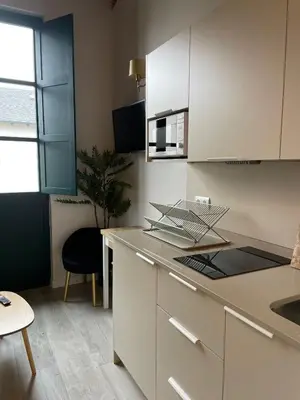 a kitchen with white cabinets and a counter top at El Granado in Cacabelos