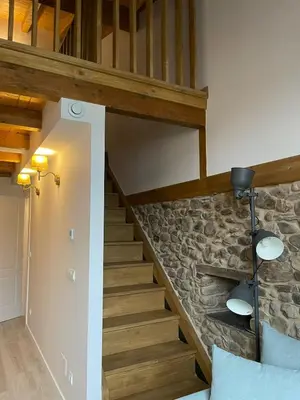 a staircase in a house with a stone wall at El Granado in Cacabelos
