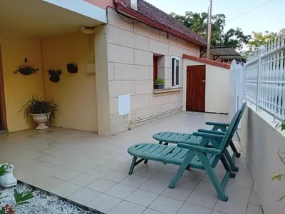 a patio with two green chairs and a house at Casa do Carpinteiro in Crecíente
