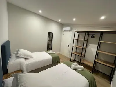a hotel room with two beds and a shelf at La casita de Pepa in Caldas de Reis