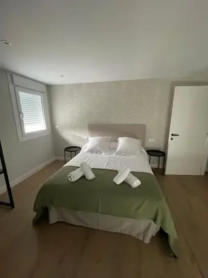 a bedroom with a large bed with two towels on it at La casita de Pepa in Caldas de Reis