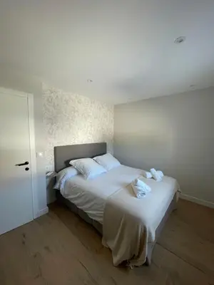 a bedroom with a large bed with white sheets at La casita de Pepa in Caldas de Reis