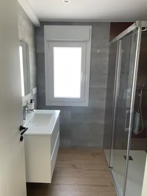 a bathroom with a white sink and a window at La casita de Pepa in Caldas de Reis