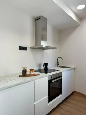 a white kitchen with a sink and a stove at Lemos Sía in Monforte de Lemos