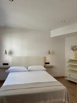 a bedroom with a large bed with white walls at Lemos Sía in Monforte de Lemos