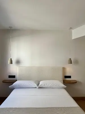 a bedroom with a white bed with two lights above it at Lemos Sía in Monforte de Lemos