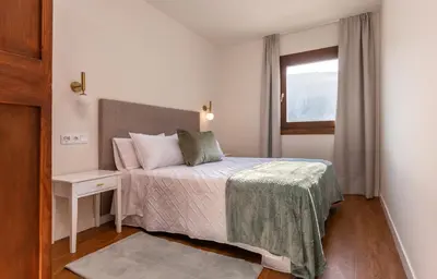 a small bedroom with a bed and a window at La Rectoral de Besullo in Besullo