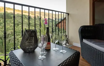 a table with three wine glasses on a balcony at La Rectoral de Besullo in Besullo