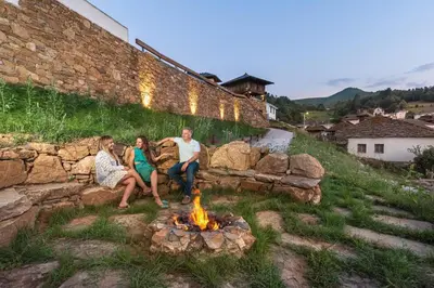 a group of people sitting around a fire pit at La Rectoral de Besullo in Besullo