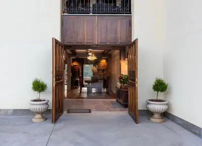 an entrance to a building with two plants in vases at La Rectoral de Besullo in Besullo