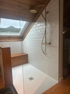 a glass shower in a room with a window at La Rectoral de Besullo in Besullo