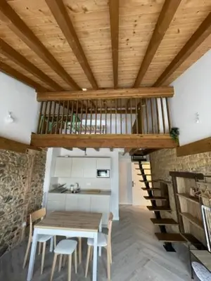 a dining room with a table and a wooden ceiling at La Higuera in Cacabelos