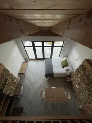 a attic view of a bedroom with a bed and a bench at La Higuera in Cacabelos