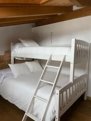 two white bunk beds with white pillows and a ladder at La Higuera in Cacabelos