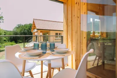 a table and chairs on the deck of a house at Cabañas de Allariz in Allariz