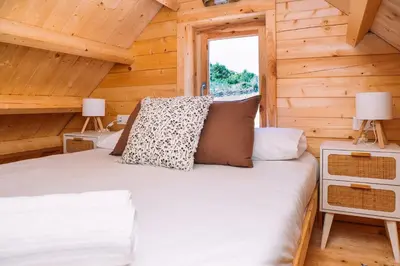 a bedroom with a bed in a log cabin at Cabañas de Allariz in Allariz