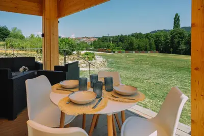 a table and chairs on a porch with a view of a field at Cabañas de Allariz - Cabaña 2 in Allariz
