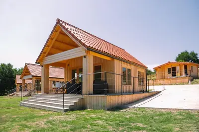 a small wooden house with a porch and stairs at Cabañas de Allariz - Cabaña 2 in Allariz