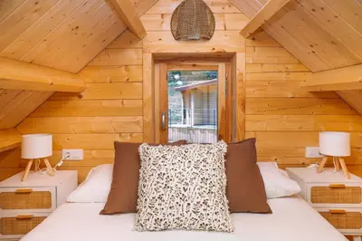 a bedroom with a bed in a log cabin at Cabañas de Allariz - Cabaña 4 in Allariz