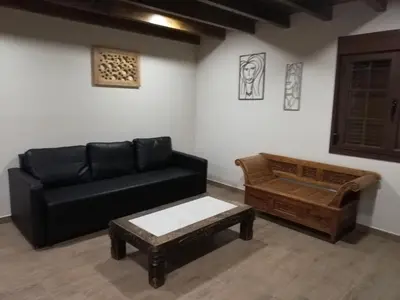 a living room with a black couch and a coffee table at Albergue la Medina de Camponaraya in Camponaraya
