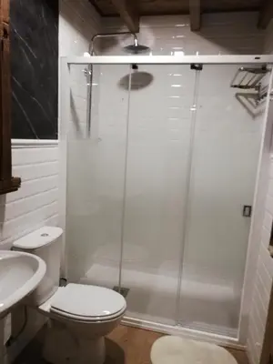 a bathroom with a shower and a toilet and a sink at Albergue la Medina de Camponaraya in Camponaraya