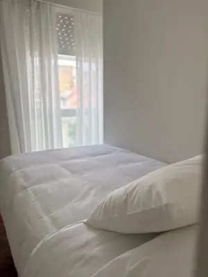a white bed in a room with a window at Cardenal Centro in Monforte de Lemos