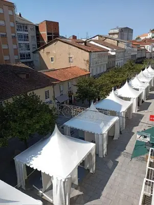 a row of white tables and umbrellas on a street at Cardenal Centro in Monforte de Lemos