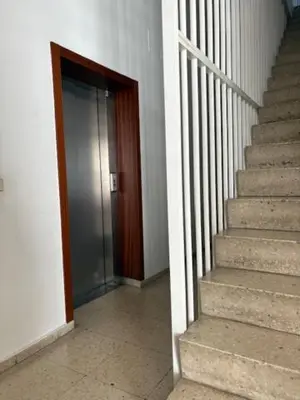 a hallway with a staircase with a door and a stair case at Cardenal Centro in Monforte de Lemos