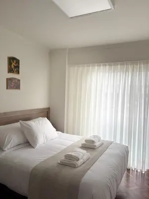 a bedroom with a bed with two towels on it at Cardenal Centro in Monforte de Lemos