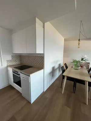 a kitchen with white cabinets and a table and a dining room at cospeito in Sada