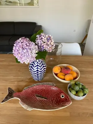 a table with a fish figurine and bowls of fruit at Casa costa de Lugo frente al mar in Nois