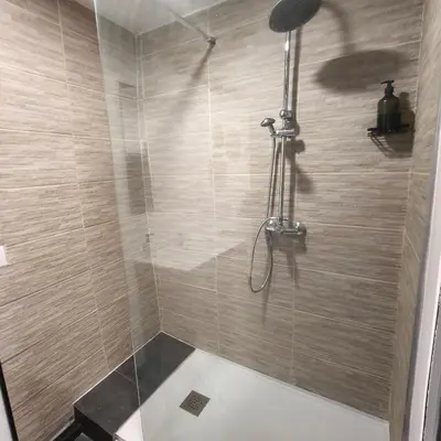 a bathroom with a shower with a tiled wall at Casa de Pedra in Melide