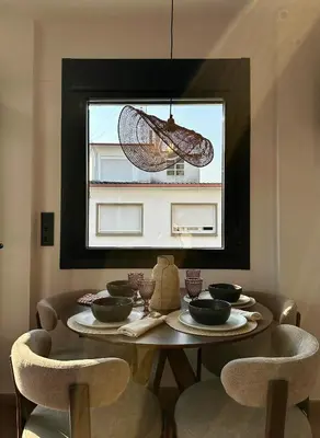 a dining room table with chairs and a window at Lemos Nai in Monforte de Lemos