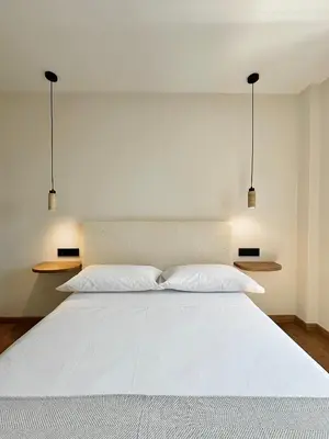 a bedroom with a white bed with two pillows at Lemos Nai in Monforte de Lemos