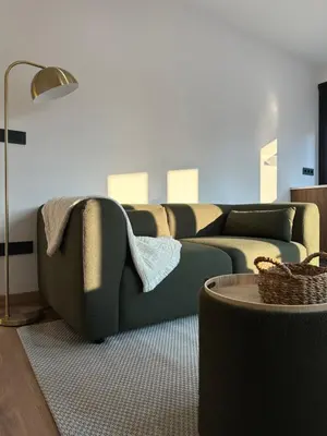 a living room with a green couch and a table at Lemos Nai in Monforte de Lemos