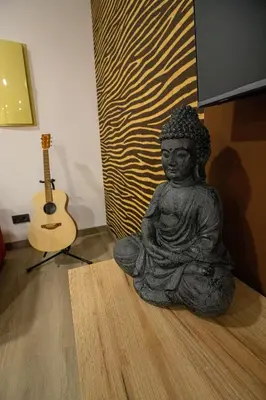 a statue sitting on the floor next to a guitar at Chuspombo Apartamentos in Baralla