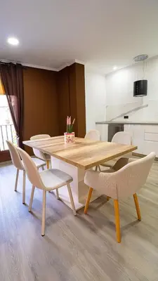 a dining room with a wooden table and chairs at Chuspombo Apartamentos in Baralla