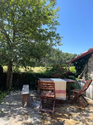 a table and two chairs sitting next to a tree at Refugio del Camino in Albá