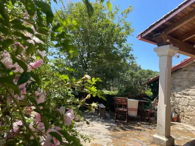 a patio with a table and chairs in a garden at Refugio del Camino in Albá