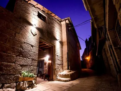 an alley with a stone building at night at Aldea Rural Pazos De Arenteiro in Pazos de Arenteiro