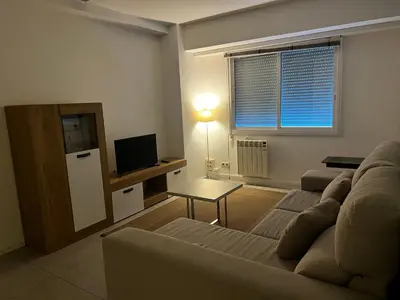 a living room with a couch and a television at Luz y Calma junto a la Catedral in Santiago de Compostela