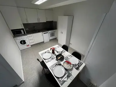 a small kitchen with a table with dishes on it at Luz y Calma junto a la Catedral in Santiago de Compostela
