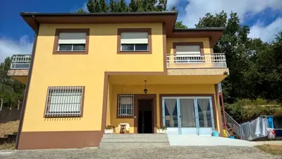 a yellow house with a balcony at Casa Do Marabillas in Portomarin