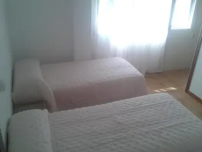 a bedroom with two beds and a window at Casa Do Marabillas in Portomarin