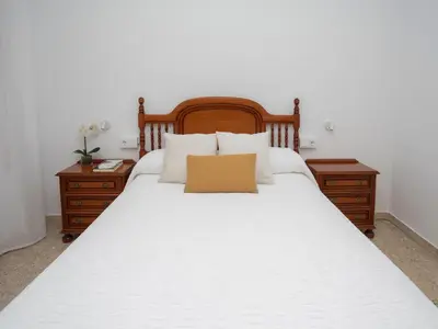 a bedroom with a large white bed with two night stands at Apartamento Río Sol in Sarria