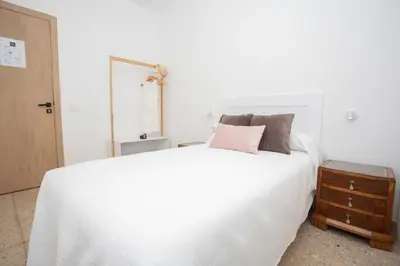 a bedroom with a large white bed and a dresser at Apartamento Río Sol in Sarria