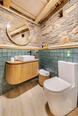 a bathroom with a toilet and a sink and a mirror at VUT La casita del Pajar in Vega de Espinareda