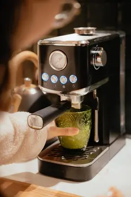 a person is making a drink in a coffee maker at VUT La casita del Pajar in Vega de Espinareda