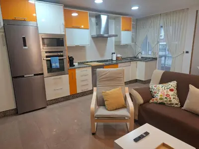 a living room with a couch and a kitchen at Apartamento Lugo Muralla in Lugo