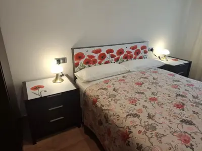a bedroom with a bed and two night stands with lamps at Apartamento Lugo Muralla in Lugo